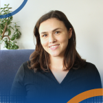 Professional headshot of Esther McKenzie seated indoors with a plant behind.