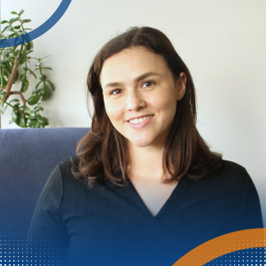 Esther McKenzie – Thrive Feeding Clinic Professional headshot of Esther McKenzie seated indoors with a plant behind.