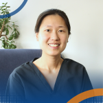 Professional headshot of Kui Noi Tan seated indoors with a plant in the background.