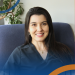 Professional headshot of Dr Stefani Knijnik seated indoors with a plant in the background.