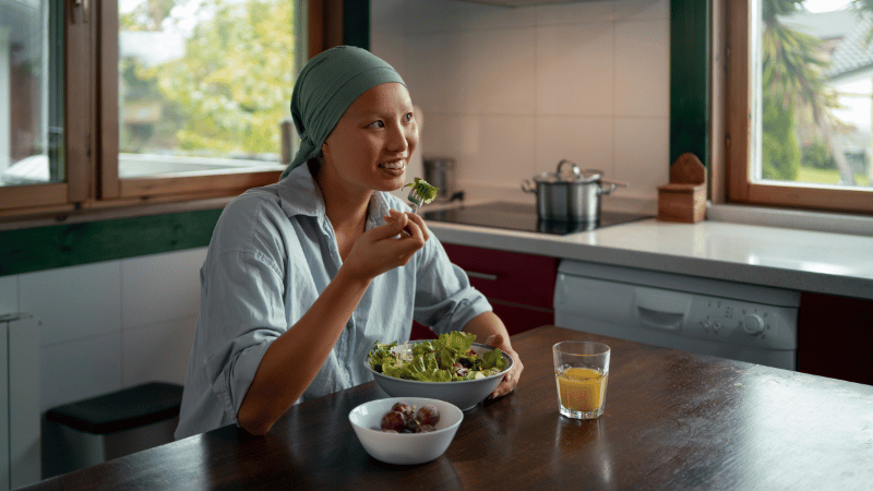 Adult eating a meal at a kitchen table, representing independent eating and everyday mealtime participation.