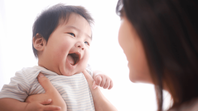 Baby interacting with a caregiver in a warm, calm moment, representing infant feeding support.