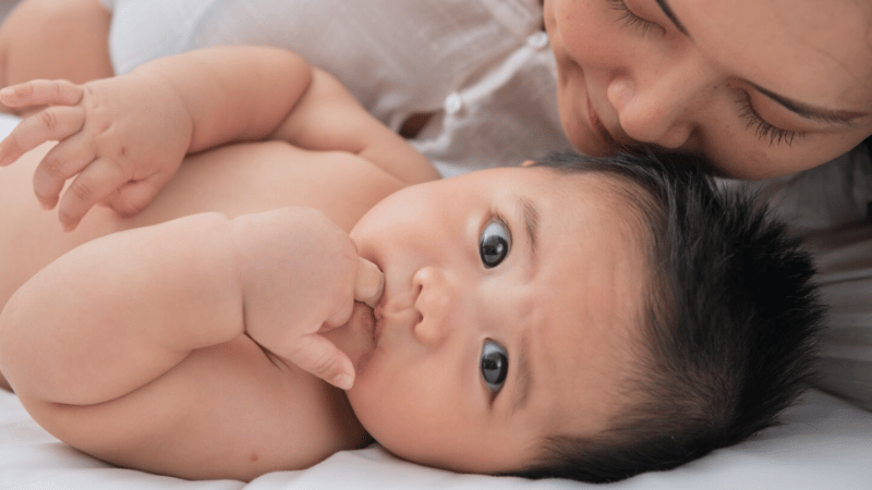 Adult cuddling closely with a newborn, representing nurturing, responsive breastfeeding and infant feeding support.