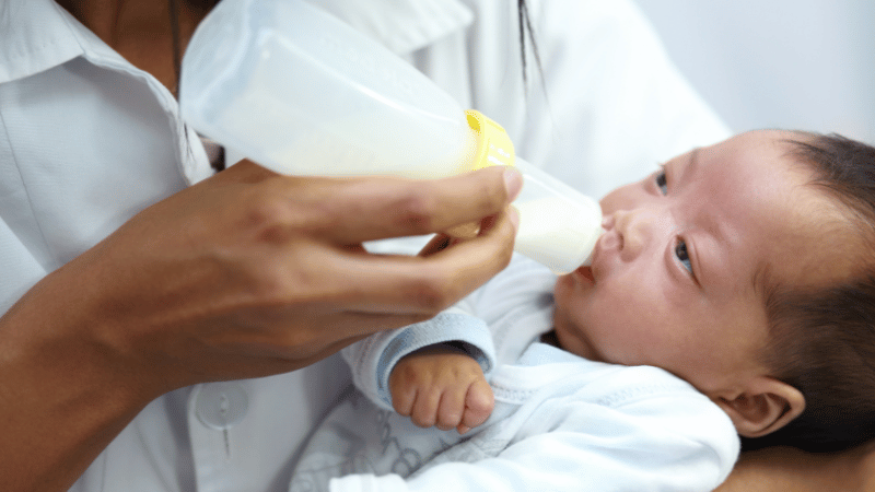 Infant being held and bottle‑fed in a calm, responsive way, representing Thrive’s inclusive, family‑centred approach to infant feeding support.