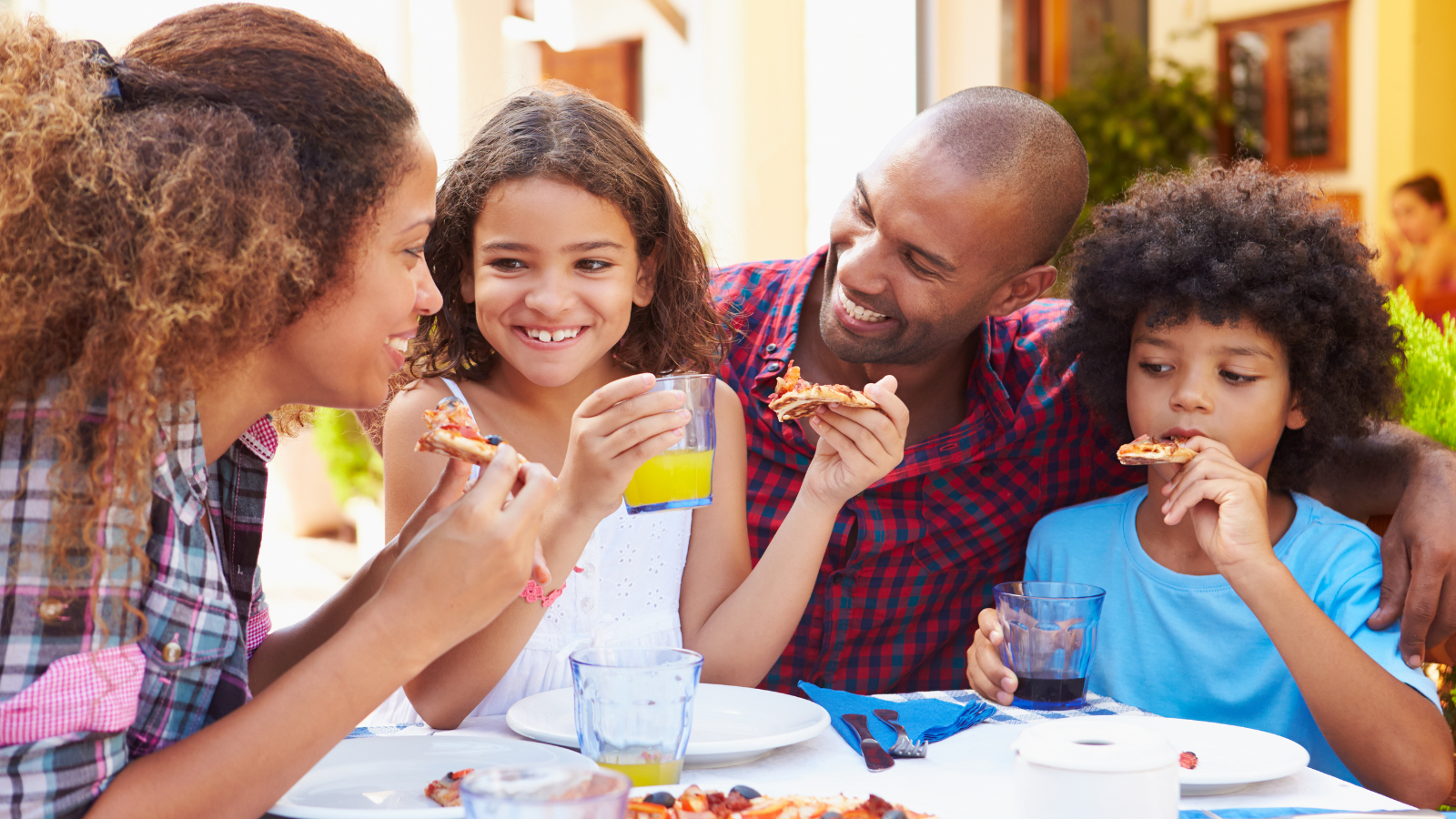 Children and adults sharing a relaxed meal outdoors, modelling low‑pressure, positive mealtime interaction.