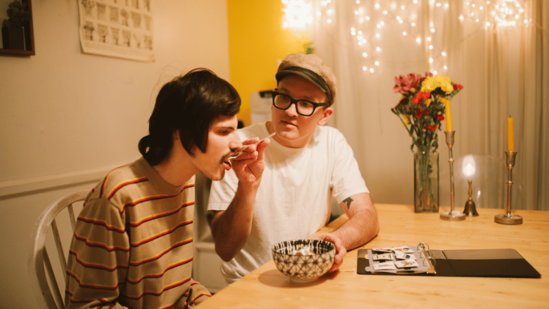 Two adults at a table during a mealtime interaction, representing mealtime participation and support‑worker training for NDIS participants.